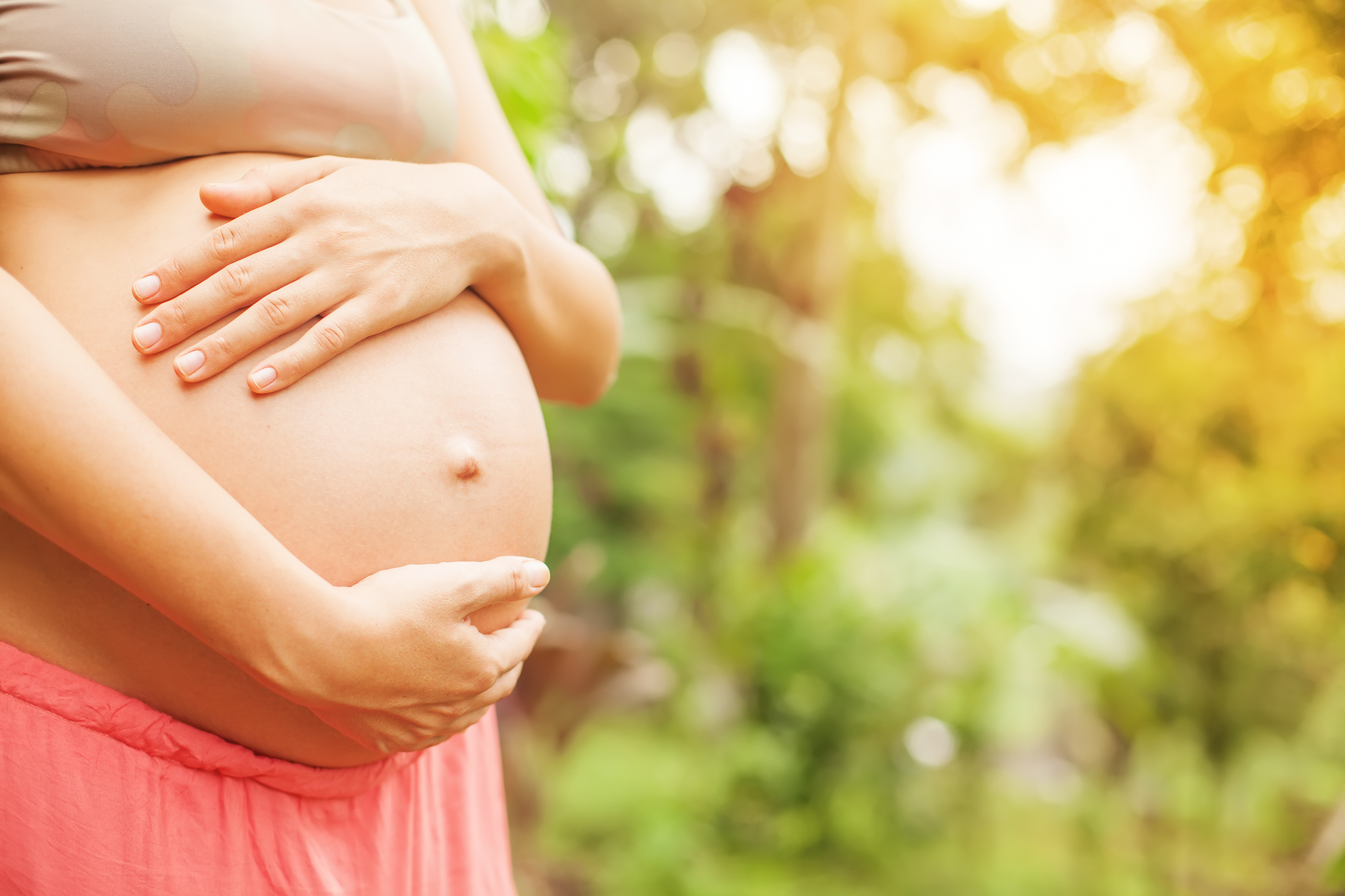 Pregnant woman touching her naked abdomen - Aquino Acupuncture & Center for  Holistic Health